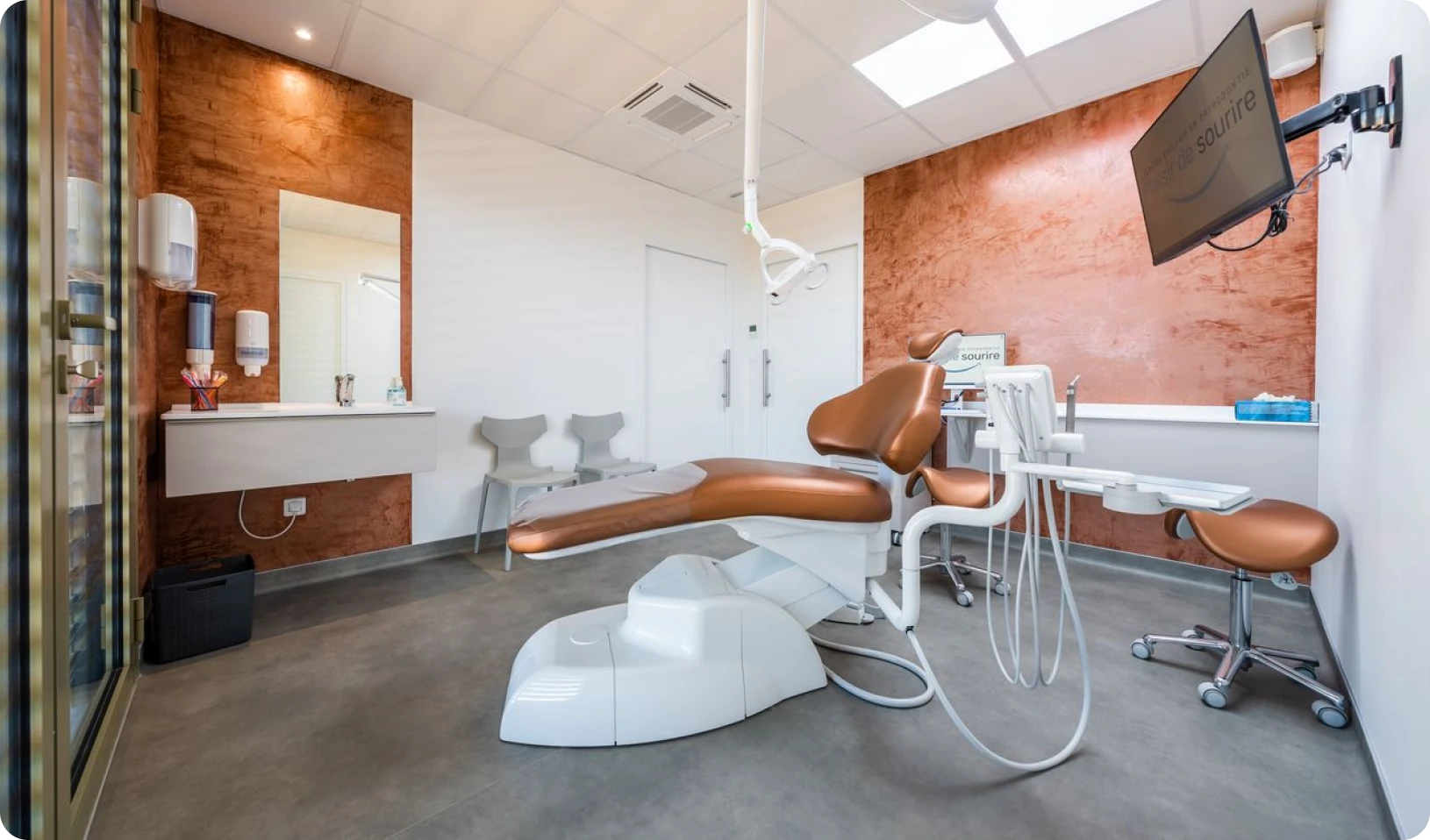Salle de soins du cabinet, fauteuil et écrans de suivi