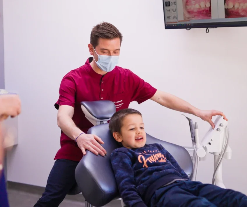 Dr Guillaume Arbouin auprès d’un enfant installé au fauteuil de soins